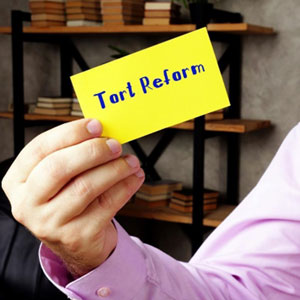 Man holding yellow paper with text "Tort Reform" - Mullins & Blake Attorneys