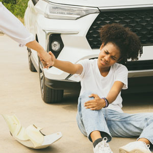 Injured pedestrian being helped after a car accident.